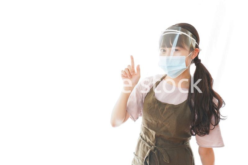 フェイスシールドを装着して指をさすカフェスタッフ