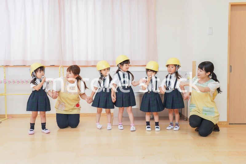 ヘルメットを被り避難する子供