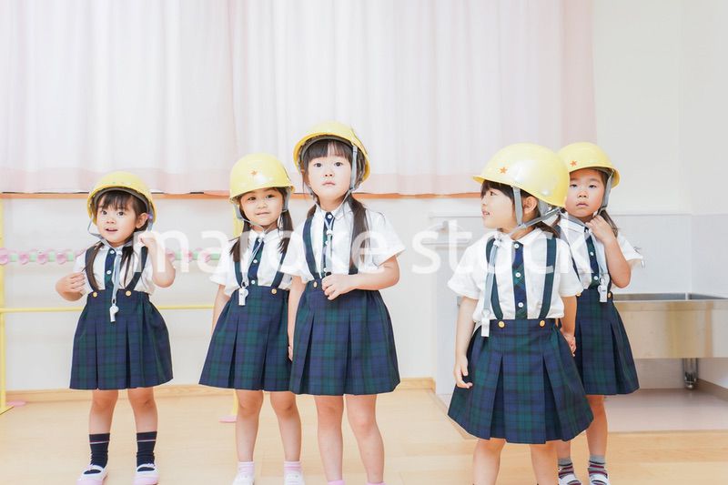 ヘルメットを被り避難する子供