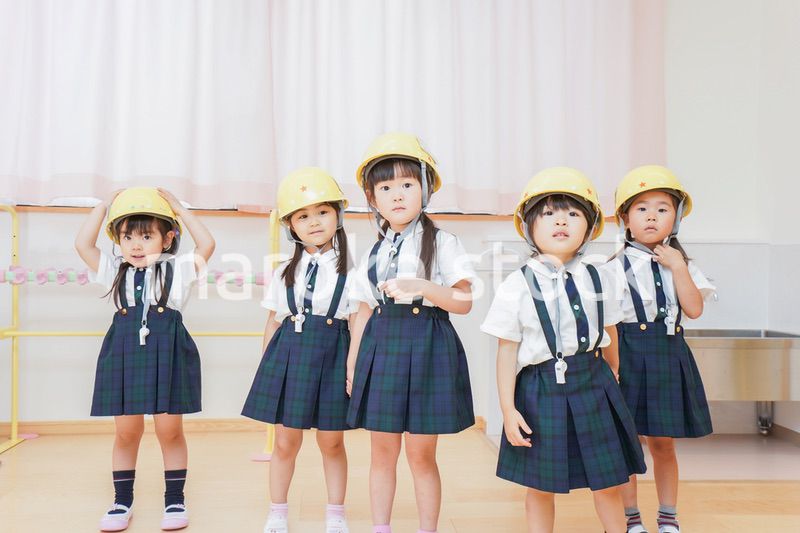 ヘルメットを被り避難する子供