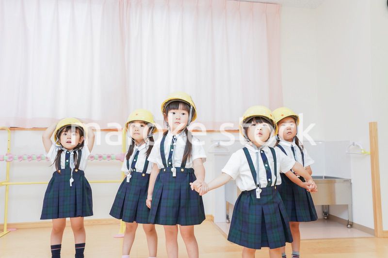 ヘルメットを被り避難する子供