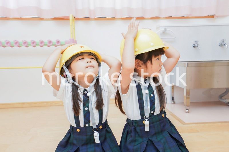 ヘルメットを被り避難する子供