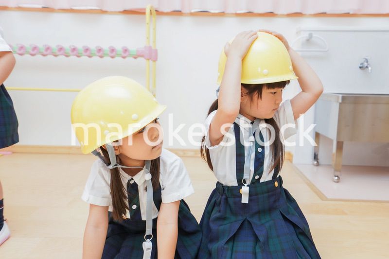 ヘルメットを被り避難する子供