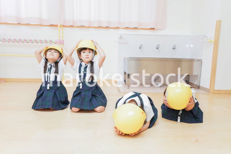 ヘルメットを被り避難する子供