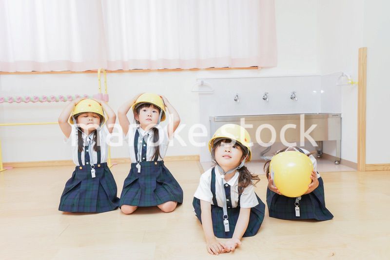 ヘルメットを被り避難する子供
