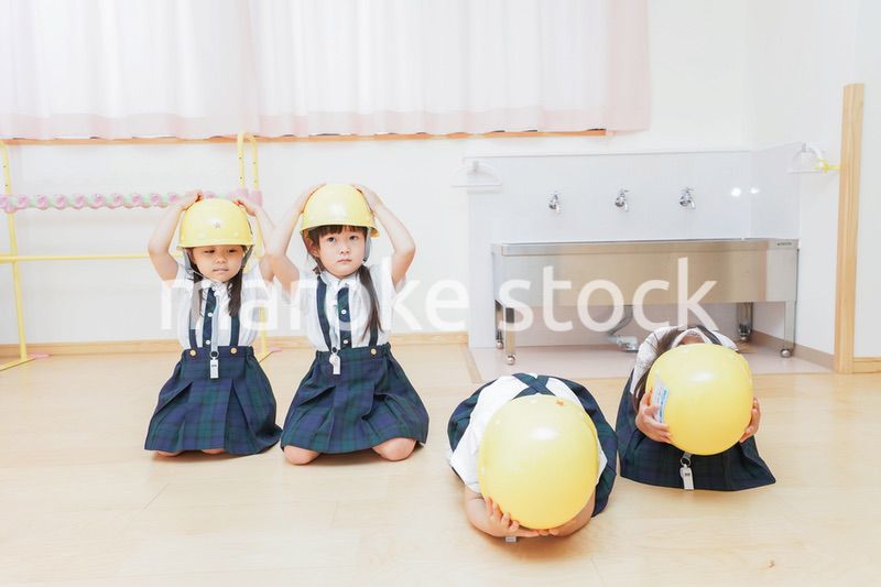 ヘルメットを被り避難する子供