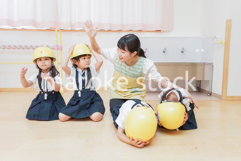 ヘルメットを被り避難する子供