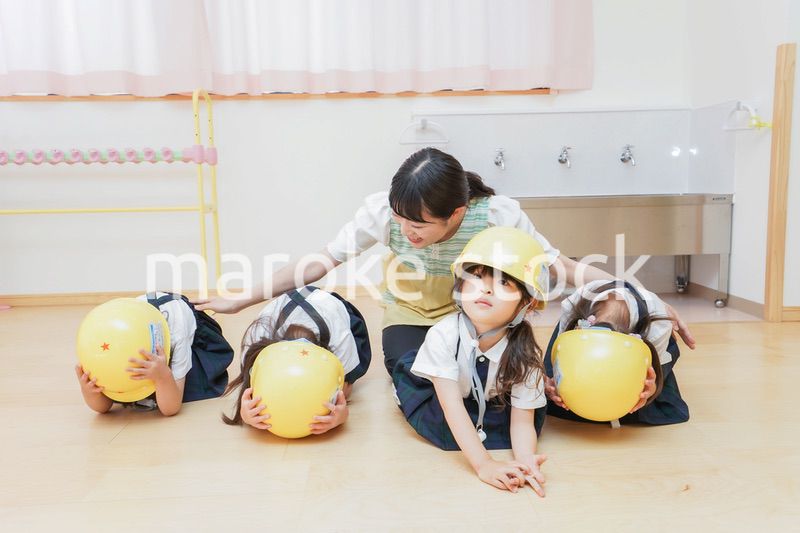 ヘルメットを被り避難する子供