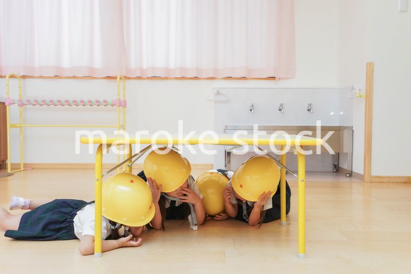 ヘルメットを被り避難する子供