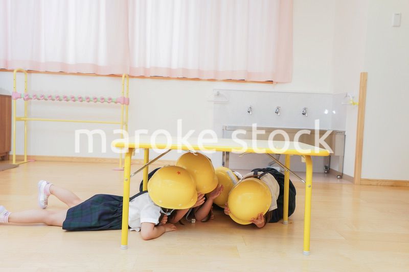 ヘルメットを被り避難する子供
