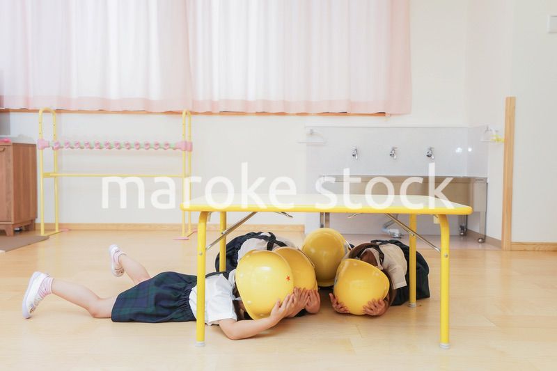 ヘルメットを被り避難する子供