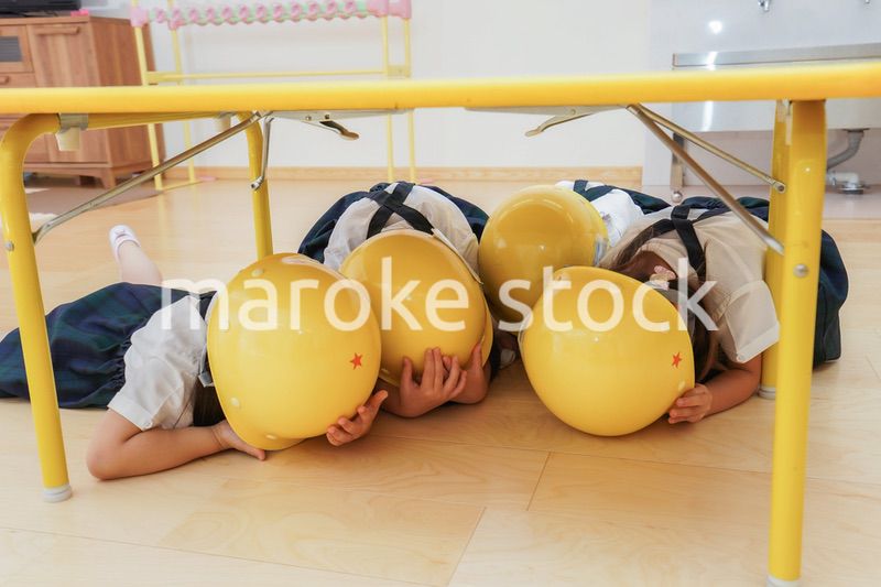 ヘルメットを被り避難する子供