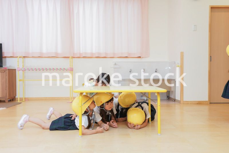 ヘルメットを被り避難する子供