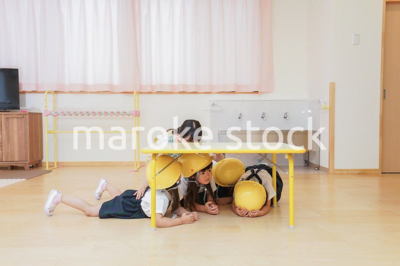 ヘルメットを被り避難する子供