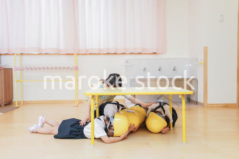 ヘルメットを被り避難する子供