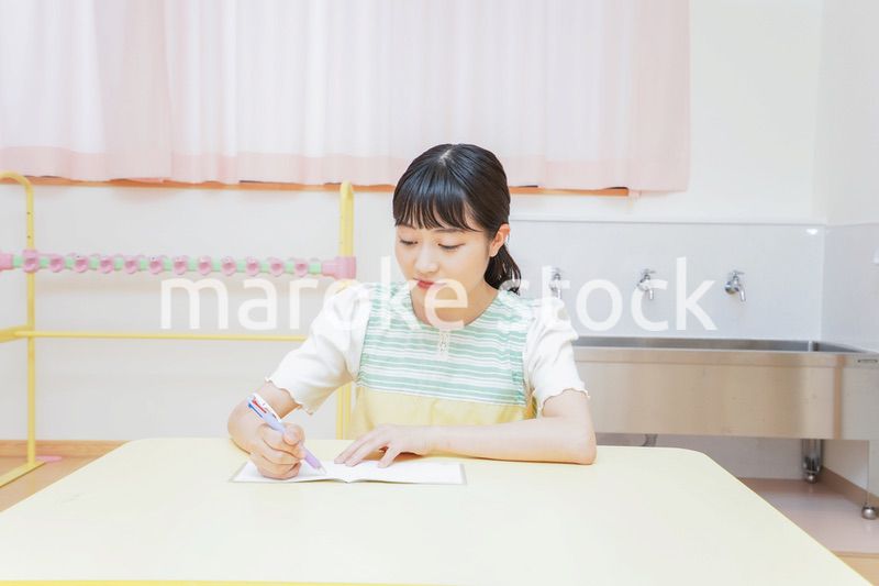 事務作業をする若い幼稚園教諭