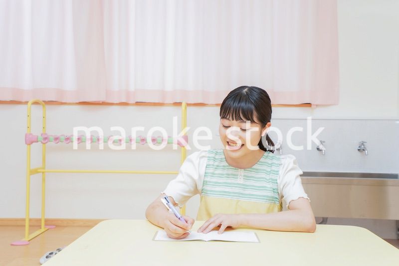 事務作業をする若い幼稚園教諭