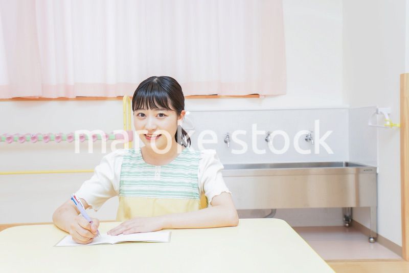 事務作業をする若い幼稚園教諭