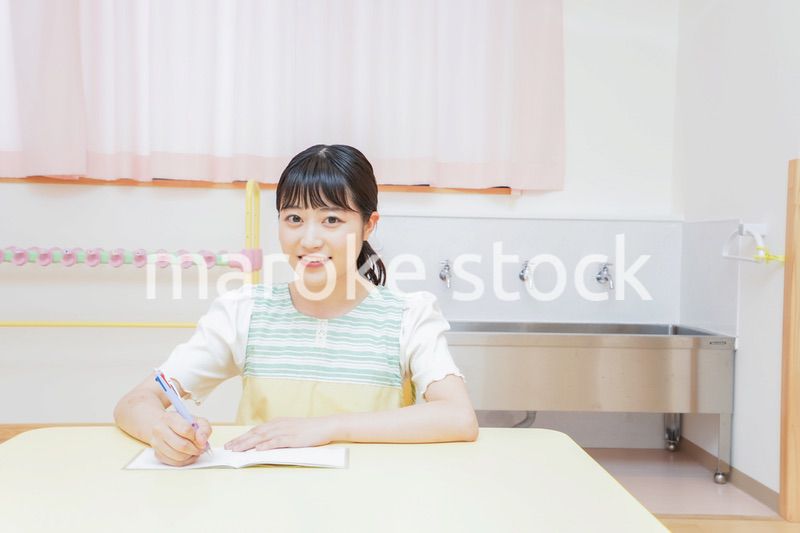 事務作業をする若い幼稚園教諭