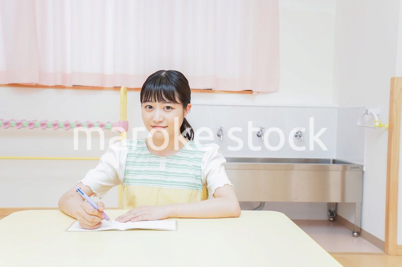 事務作業をする若い幼稚園教諭