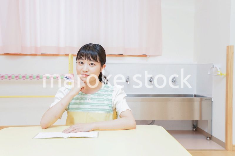 事務作業をする若い幼稚園教諭