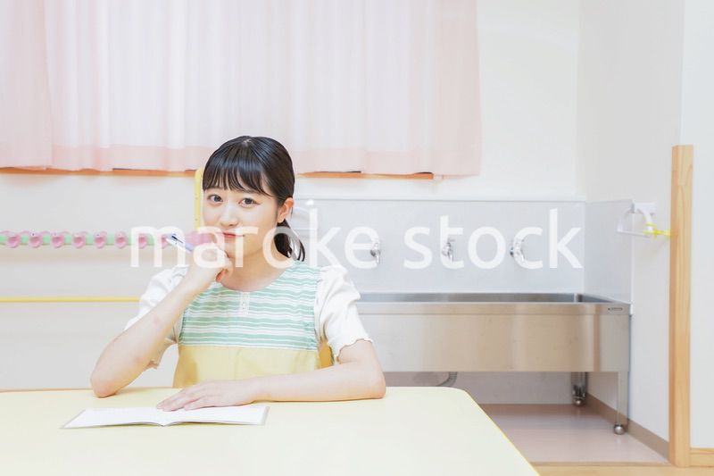 事務作業をする若い幼稚園教諭