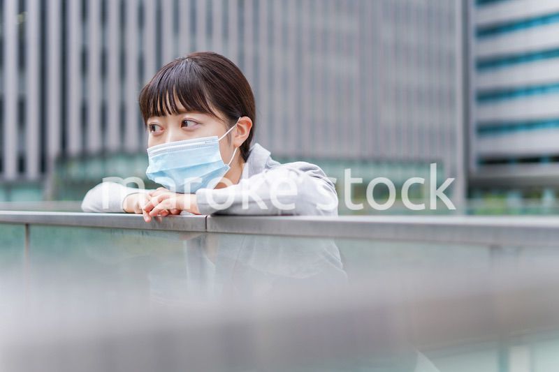 マスクをして外で休憩をする若いビジネスウーマン