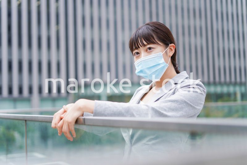 マスクをして外で休憩をする若いビジネスウーマン