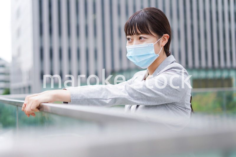 マスクをして外で休憩をする若いビジネスウーマン