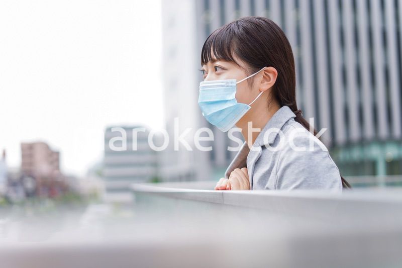 マスクをして外で休憩をする若いビジネスウーマン