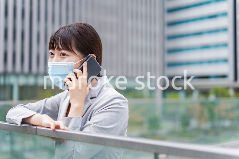 マスクをして電話をする若いビジネスウーマン