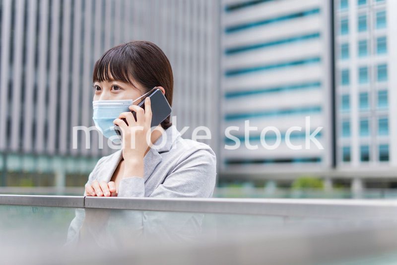 マスクをして電話をする若いビジネスウーマン
