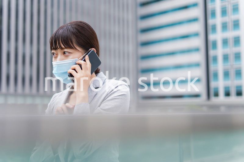 マスクをして電話をする若いビジネスウーマン