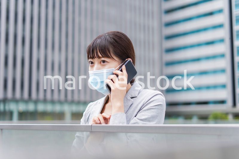 マスクをして電話をする若いビジネスウーマン