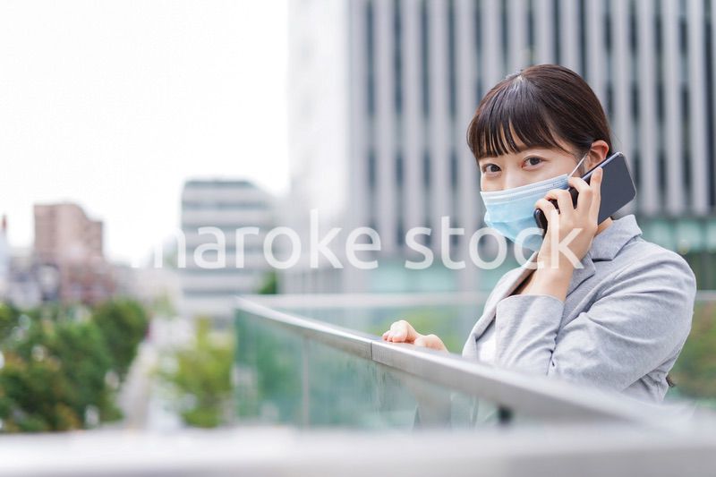 マスクをして電話をする若いビジネスウーマン