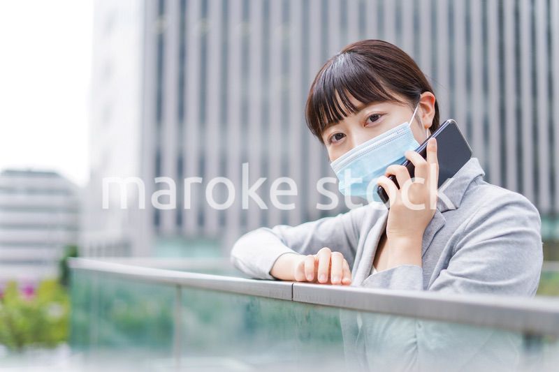 マスクをして電話をする若いビジネスウーマン