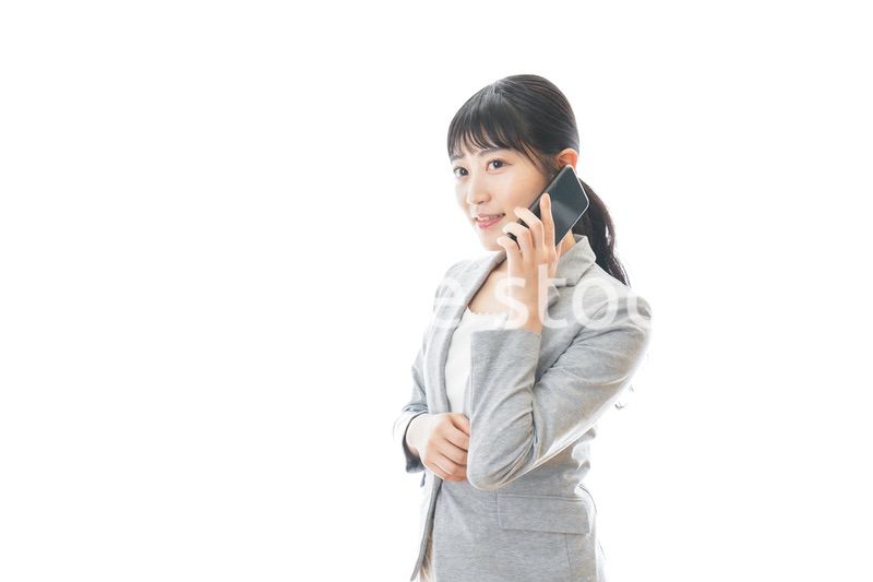 スマホで通話をする笑顔のビジネスウーマン