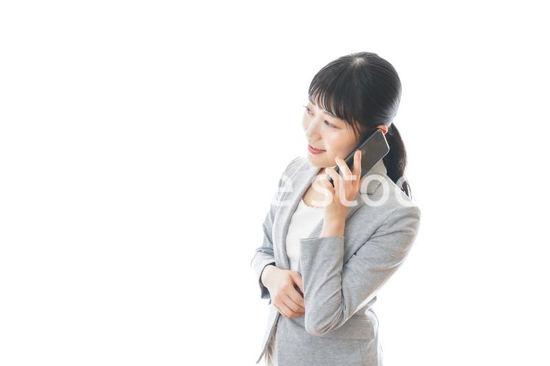 スマホで通話をする笑顔のビジネスウーマン