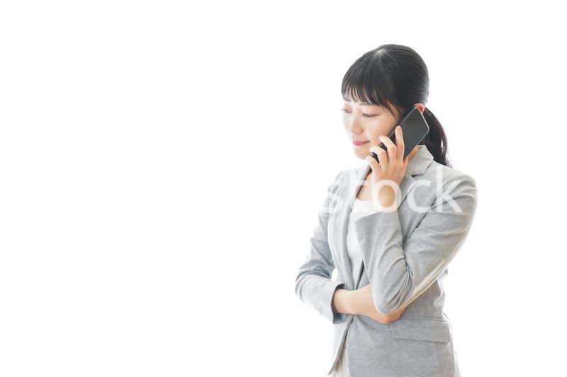 スマホで通話をする笑顔のビジネスウーマン