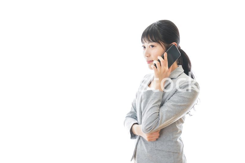 スマホで通話をする笑顔のビジネスウーマン