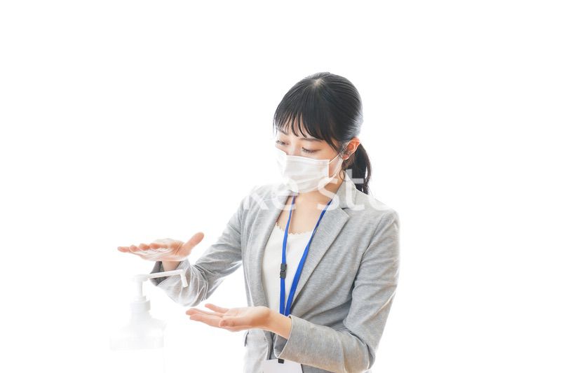 アルコール消毒液を使う若いビジネスパーソン