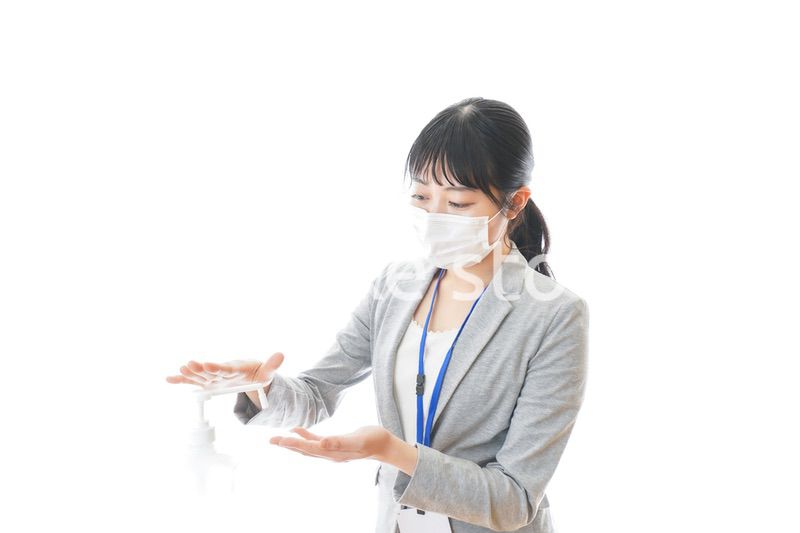 アルコール消毒液を使う若いビジネスパーソン