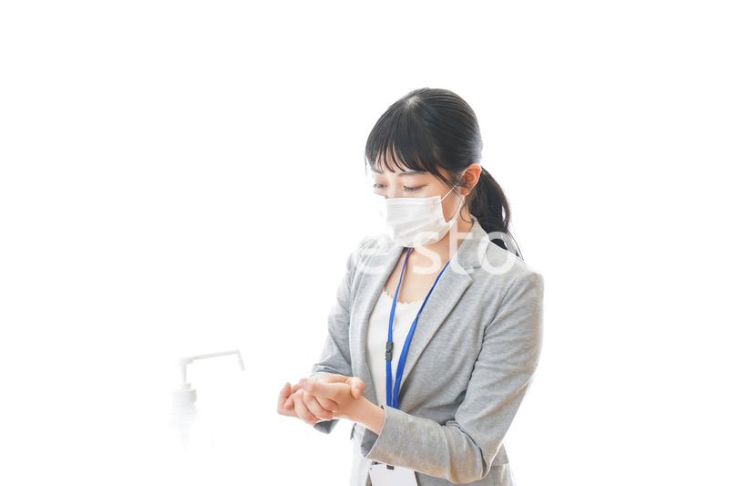 アルコール消毒液を使う若いビジネスパーソン