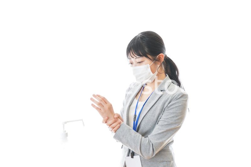 アルコール消毒液を使う若いビジネスパーソン