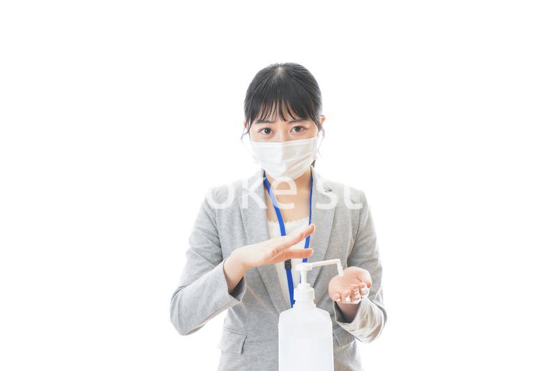 アルコール消毒液を使う若いビジネスパーソン