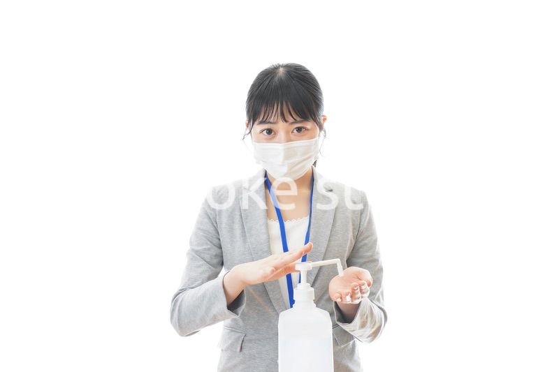 アルコール消毒液を使う若いビジネスパーソン