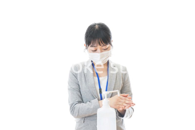 アルコール消毒液を使う若いビジネスパーソン