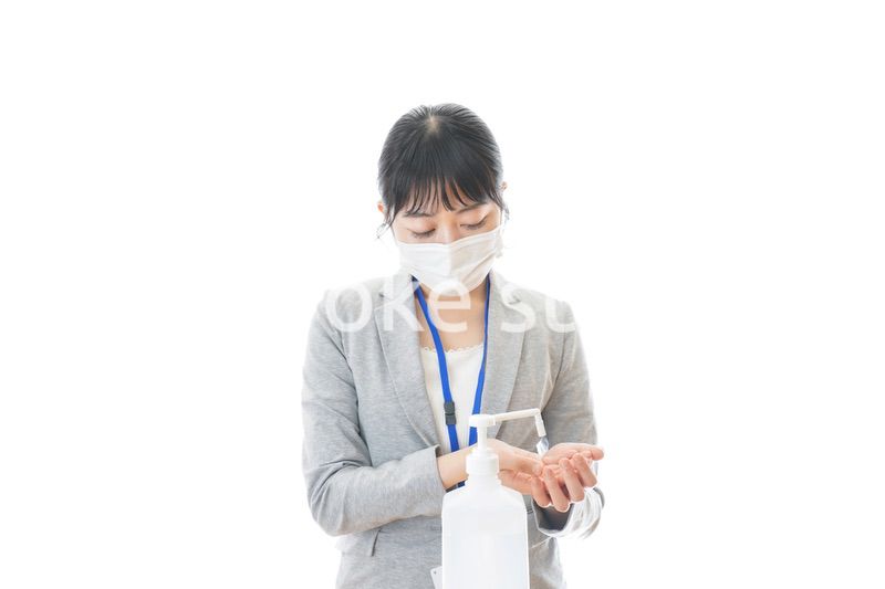 アルコール消毒液を使う若いビジネスパーソン