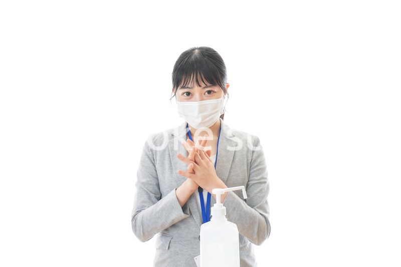 アルコール消毒液を使う若いビジネスパーソン
