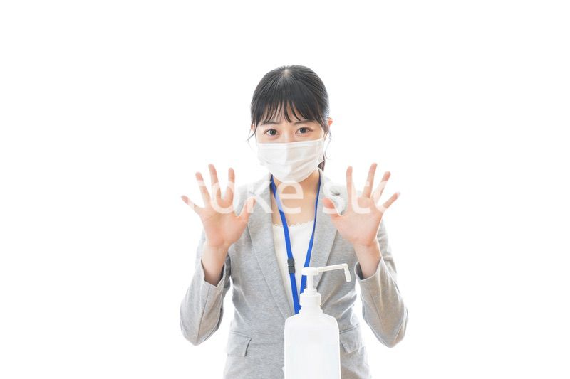 アルコール消毒液を使う若いビジネスパーソン